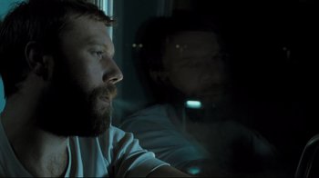 Movie still from “Submarino” (2010), directed by Thomas Vinterberg – A man sitting next to another man in a dark room; Close Up shot, Over the shoulder angle