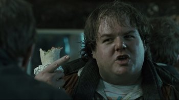 Movie still from “Submarino” (2010), directed by Thomas Vinterberg – A man holding a piece of food in front of his face; Close Up shot, Over the shoulder angle