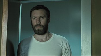 Movie still from “Submarino” (2010), directed by Thomas Vinterberg – A man with a long beard is looking at the camera; Close Up shot, Low angle