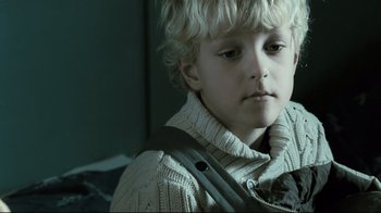 Movie still from “Submarino” (2010), directed by Thomas Vinterberg – A young boy wearing a sweater and a tie; Close Up shot, Low angle