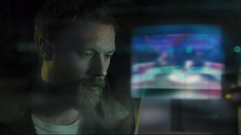 Movie still from “Submarino” (2010), directed by Thomas Vinterberg – A bearded man sitting in front of a television; Close Up shot, Over the shoulder angle