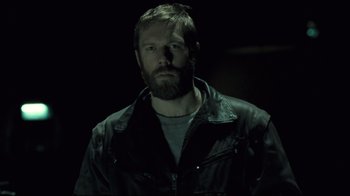 Movie still from “Submarino” (2010), directed by Thomas Vinterberg – A man with a goatee and a beard in the dark; Close Up shot, Low angle