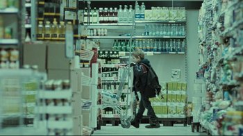 Movie still from “Submarino” (2010), directed by Thomas Vinterberg – A person is pushing a shopping cart in a store; Wide shot, Over the shoulder angle