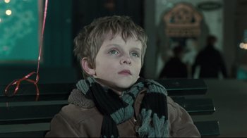 Movie still from “Submarino” (2010), directed by Thomas Vinterberg – A young boy wearing a jacket and a scarf; Close Up shot, Low angle