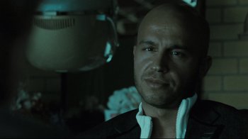 Movie still from “Submarino” (2010), directed by Thomas Vinterberg – A man with a bald head is looking at the camera; Close Up shot, Low angle