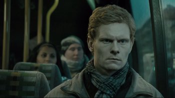 Movie still from “Submarino” (2010), directed by Thomas Vinterberg – A man with a scarf on his head is on a bus; Close Up shot, Low angle