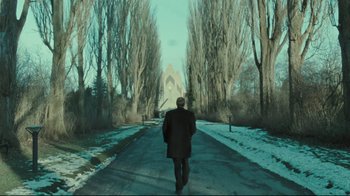 Movie still from “Submarino” (2010), directed by Thomas Vinterberg – A man walking down a road in the middle of the day; Wide shot, Low angle