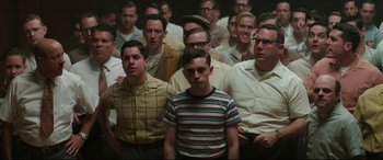 Movie still from “Suburbicon” (2017), directed by George Clooney – A group of men standing in front of each other in a room; Medium shot, High angle