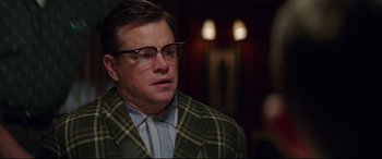 Movie still from “Suburbicon” (2017), directed by George Clooney – A person wearing a suit and glasses; Close Up shot, Over the shoulder angle