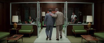 Movie still from “Suburbicon” (2017), directed by George Clooney – A couple of men walking down a hall way; Wide shot, Low angle