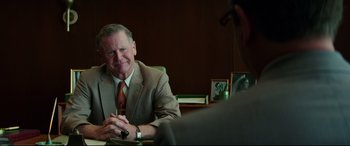 Movie still from “Suburbicon” (2017), directed by George Clooney – A man sitting at a table with a man in a suit and tie; Medium shot, Over the shoulder angle