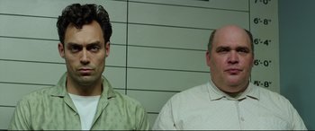Movie still from “Suburbicon” (2017), directed by George Clooney – Two men standing next to each other in front of a wall; Close Up shot, Low angle