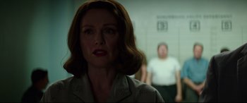 Movie still from “Suburbicon” (2017), directed by George Clooney – A woman in a white shirt and a man in a white t - shirt in the background; Close Up shot, Low angle