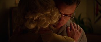 Movie still from “Suburbicon” (2017), directed by George Clooney – An older woman with blonde curly hair and glasses looking at another older woman with blonde curly hair; Close Up shot, Over the shoulder angle