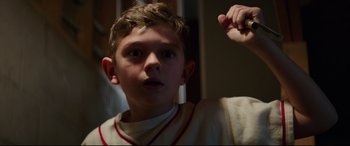 Movie still from “Suburbicon” (2017), directed by George Clooney – A young boy is looking up at the camera; Close Up shot, Low angle