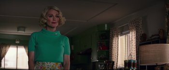 Movie still from “Suburbicon” (2017), directed by George Clooney – A woman standing in a room wearing a green shirt; Medium shot, Low angle