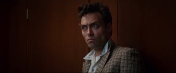 Movie still from “Suburbicon” (2017), directed by George Clooney – A person wearing a suit and tie; Close Up shot, Low angle