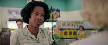 Movie still from “Suburbicon” (2017), directed by George Clooney – A woman standing in front of shelves of books; Close Up shot, Over the shoulder angle