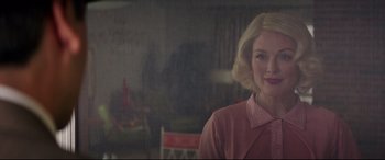 Movie still from “Suburbicon” (2017), directed by George Clooney – A woman with blonde hair wearing a pink jacket; Medium shot, Over the shoulder angle
