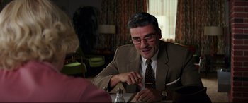 Movie still from “Suburbicon” (2017), directed by George Clooney – A man sitting at a table with a pen in his hand; Medium shot, Over the shoulder angle