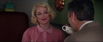 Movie still from “Suburbicon” (2017), directed by George Clooney – A woman in a pink shirt is taking a picture; Close Up shot, Over the shoulder angle