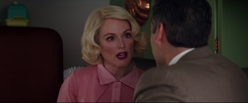 Movie still from “Suburbicon” (2017), directed by George Clooney – A woman in a pink dress talking to a man in a brown suit; Close Up shot, Over the shoulder angle