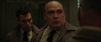 Movie still from “Suburbicon” (2017), directed by George Clooney – A man in a suit and tie next to another man in a suit and tie; Close Up shot, Low angle