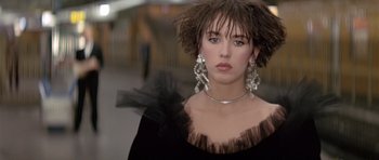 A person wearing a dress and a pair of earrings