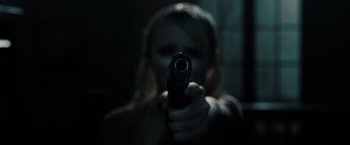 Movie still from “Sucker Punch” (2011), directed by Zack Snyder – A woman holding a gun in a dark room; Extreme Close Up shot, Low angle