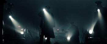 Movie still from “Sucker Punch” (2011), directed by Zack Snyder – A man standing in front of a car at night with a flashlight; Medium shot, Low angle