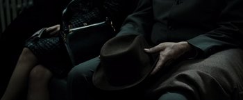 Movie still from “Sucker Punch” (2011), directed by Zack Snyder – A person sitting in a chair wearing a hat; Extreme Close Up shot, High angle