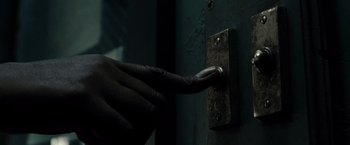 Movie still from “Sucker Punch” (2011), directed by Zack Snyder – A person in black gloves is pulling on a door knob; Extreme Close Up shot, High angle