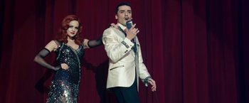 Movie still from “Sucker Punch” (2011), directed by Zack Snyder – A man and a woman singing on stage; Medium shot, Low angle
