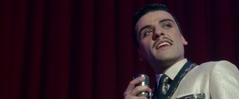 Movie still from “Sucker Punch” (2011), directed by Zack Snyder – A person holding a microphone; Close Up shot, Low angle