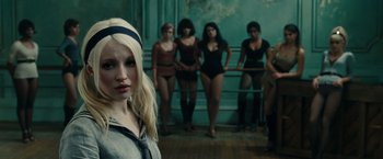 Movie still from “Sucker Punch” (2011), directed by Zack Snyder – A woman standing in front of a group of women; Close Up shot, Over the shoulder angle