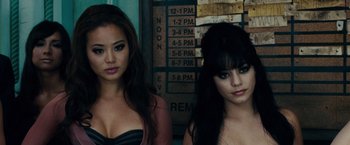 Movie still from “Sucker Punch” (2011), directed by Zack Snyder – Two young women standing next to each other in front of a sign; Close Up shot, Low angle