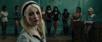 Movie still from “Sucker Punch” (2011), directed by Zack Snyder – A woman standing in front of a group of women; Close Up shot, Over the shoulder angle