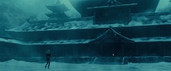 Movie still from “Sucker Punch” (2011), directed by Zack Snyder – A man standing in front of a building in the snow; Extreme Wide shot, Low angle