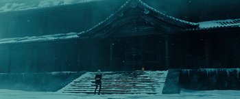 Movie still from “Sucker Punch” (2011), directed by Zack Snyder – A person standing in the middle of a snow covered staircase; Extreme Wide shot, Low angle