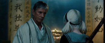 Movie still from “Sucker Punch” (2011), directed by Zack Snyder – A man and a woman are standing next to each other; Close Up shot, Over the shoulder angle