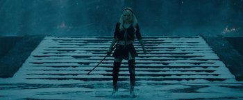 Movie still from “Sucker Punch” (2011), directed by Zack Snyder – A woman standing in the snow holding a sword; Wide shot, High angle
