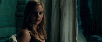 Movie still from “Sucker Punch” (2011), directed by Zack Snyder – A woman with long blonde hair standing in front of a curtain; Close Up shot, Over the shoulder angle