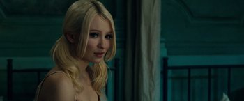 Movie still from “Sucker Punch” (2011), directed by Zack Snyder – A beautiful young lady with blonde hair standing next to a wall; Close Up shot, Over the shoulder angle