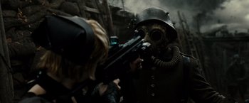 Movie still from “Sucker Punch” (2011), directed by Zack Snyder – A person wearing a gas mask and holding a gun; Close Up shot, Over the shoulder angle