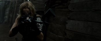 Movie still from “Sucker Punch” (2011), directed by Zack Snyder – A woman in a leather jacket holding a gun; Medium shot, Over the shoulder angle