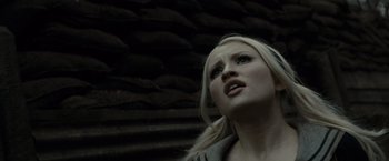 Movie still from “Sucker Punch” (2011), directed by Zack Snyder – A woman's face in front of a stone wall; Close Up shot, Low angle