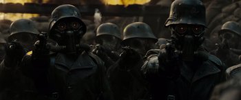 Movie still from “Sucker Punch” (2011), directed by Zack Snyder – A group of men wearing helmets and gas masks; Close Up shot, Low angle