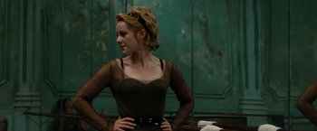 Movie still from “Sucker Punch” (2011), directed by Zack Snyder – A woman standing in front of a green wall with her hands on her hips; Medium shot, Over the shoulder angle