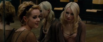 Movie still from “Sucker Punch” (2011), directed by Zack Snyder – A group of women sitting next to each other on the floor; Close Up shot, Over the shoulder angle