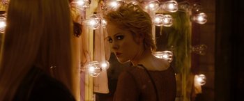 Movie still from “Sucker Punch” (2011), directed by Zack Snyder – A woman standing in front of a bunch of lights; Close Up shot, Over the shoulder angle